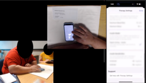 Screenshot of a recording from a study session. In the top left corner there is an overhead view of someone's hand on a phone, in the bottom left there is a view of the room with the participant, and on the right side there is a large view of the phone screen which is directly mirrored.